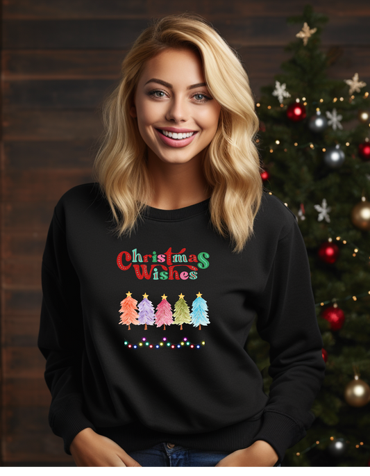 Woman wearing a black sweatshirt with 'Christmas Wishes' and Christmas tree design in front of a decorated Christmas tree.